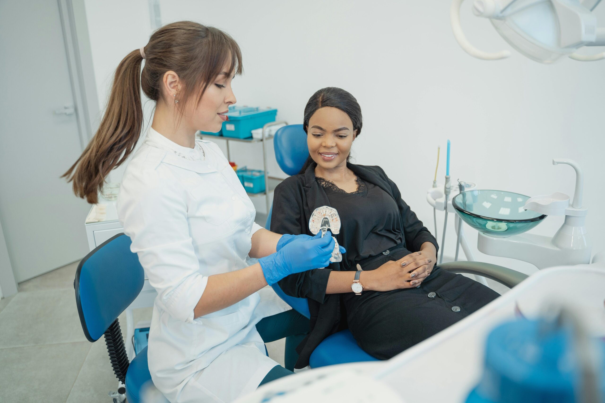 Dentist explaining dental procedure to patient in a modern clinic setting.